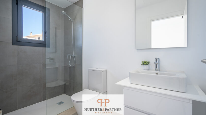 Modernes Badezimmer der Neubau-Doppelhaushälfte in Cala Romàntica mit Dusche, WC und Waschtisch