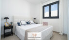Helles Schlafzimmer mit Doppelbett, dunklen Nachttischen und Fenster in Neubau-Doppelhaushälfte, Cala Romàntica