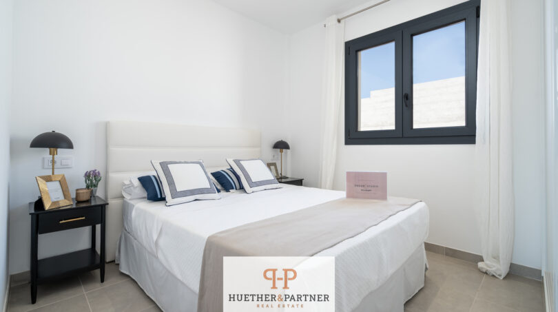 Helles Schlafzimmer mit Doppelbett, dunklen Nachttischen und Fenster in Neubau-Doppelhaushälfte, Cala Romàntica
