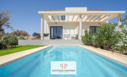 Außenansicht moderne Neubau-Villa in Cala Romàntica mit privatem Pool, Pergola-Terrasse und mediterranem Garten.