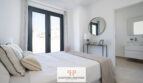 Helles Schlafzimmer der Neubau-Doppelhaushälfte in Cala Romàntica mit Doppelbett und Terrassenzugang