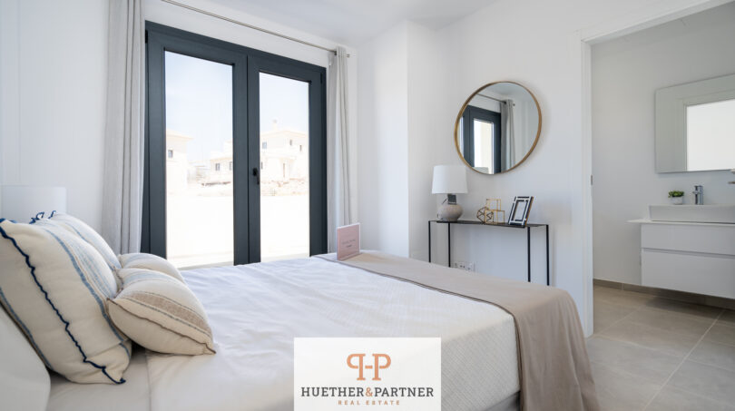 Helles Schlafzimmer der Neubau-Doppelhaushälfte in Cala Romàntica mit Doppelbett und Terrassenzugang