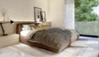 Helles Schlafzimmer der Neubauvilla in Calvià mit Doppelbett, Holzkopfteil und Panoramafenster zum Grün.
