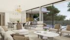 Helles Wohnzimmer der Neubauvilla in Calvià mit Panoramaverglasung, Blick auf Pool und Garten.