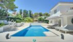 Moderner Pool mit Sonnenliegen und weißer Villa in Santa Ponça, umgeben von mediterranem Grün.