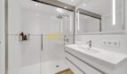 Modernes Badezimmer mit begehbarer Dusche, Doppelwaschbecken und hochwertiger Spiegelbeleuchtung