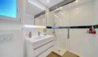 Modernes Badezimmer der Villa in Santa Ponça mit Glasdusche, Waschtisch und Spiegelschrank.
