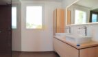 Modernes Badezimmer der Neubau Villa in Sol de Mallorca mit Doppelwaschbecken und ebenerdiger Dusche.