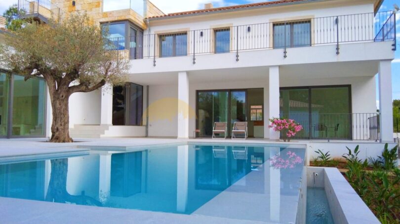 Neubau Villa Sol de Mallorca: Außenpool mit Blick auf weiße Fassade, Balkon, Olivenbaum und Bougainvillea