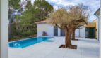 Moderner Außenbereich der Neubau-Villa in Sol de Mallorca mit Pool, Olivenbaum und Gästehaus