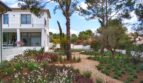 Neubau Villa Sol de Mallorca: Mediterraner Garten mit Natursteinweg, Pinien und bunten Blüten