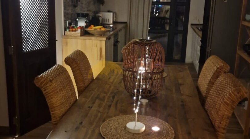 Rustikales Esszimmer mit Gewölbedecke, langem Holztisch und Korbstühlen in der Finca Felanitx