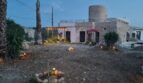 Beleuchteter Außenbereich der Finca in Felanitx bei Dämmerung mit Steinturm, Palmen und mediterranem Garten.