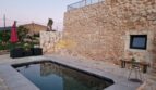 Finca Felanitx: Natursteinhaus mit rechteckigem Pool, Terrasse und Lounge-Bereich im Abendlicht