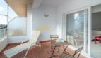 Sonniger Balkon mit Liegestuhl, Bistrotisch und Stühlen, Terrakottafliesen und Zugang zum Wohnbereich in Arenal