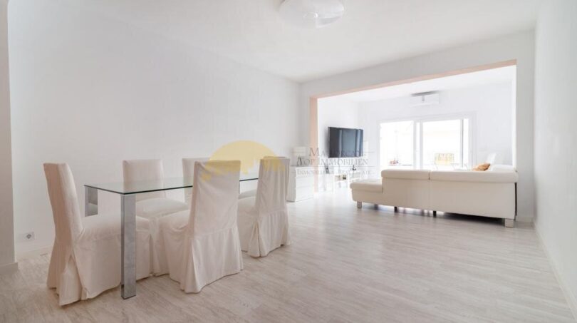 Helles Wohn- und Esszimmer mit Glasstisch, weißen Stühlen und modernem TV in zentraler Wohnung in Arenal, Palma