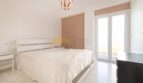 Helles Schlafzimmer mit Doppelbett, weißen Möbeln, Parkettboden und Balkonzugang in modernisierter Wohnung in Arenal, Palma.