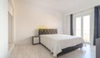 Helles Schlafzimmer mit Doppelbett, Parkettboden und Balkonzugang in modernisierter Wohnung in Arenal, Palma.