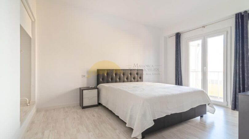 Helles Schlafzimmer mit Doppelbett, Parkettboden und Balkonzugang in modernisierter Wohnung in Arenal, Palma.