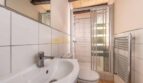 Badezimmer der Finca in Son Macià mit Waschbecken, Duschkabine, WC und Heizkörper