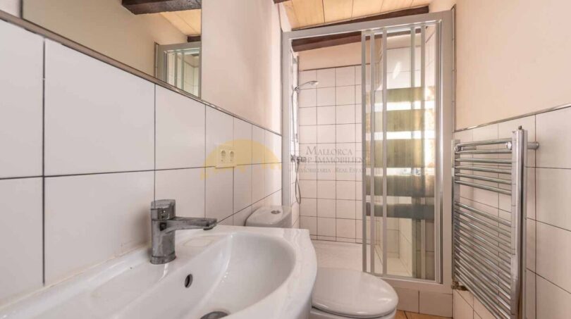 Badezimmer der Finca in Son Macià mit Waschbecken, Duschkabine, WC und Heizkörper
