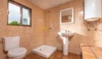 Badezimmer der Finca in Son Macià mit Dusche, WC, Waschbecken und Fliesenwänden in Sandtönen