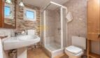 Helles Badezimmer der Finca mit Duschkabine, WC, Waschtisch und Natursteinwand in Son Macià