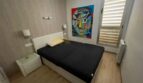 Helles Schlafzimmer mit Doppelbett, Holzboden, modernem Kunstgemälde und Fensterläden im Strandapartment Magaluf.