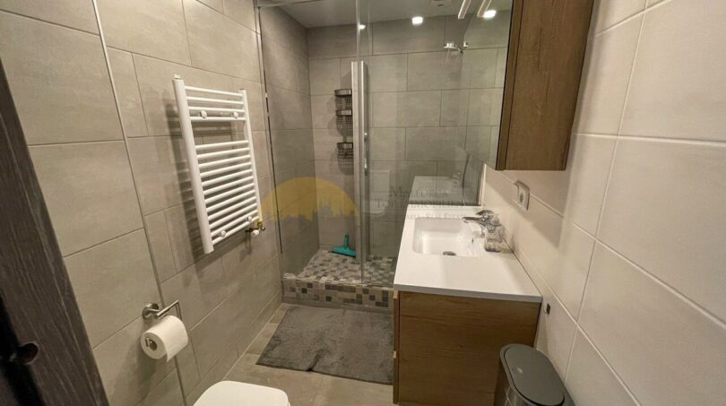 Modernes Badezimmer mit Glasdusche, Handtuchheizung und Holzunterschrank im Strandapartment Magaluf