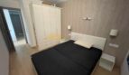 Schlafzimmer mit Doppelbett, weißem Kleiderschrank und Wandlampen im renovierten Strandapartment Magaluf