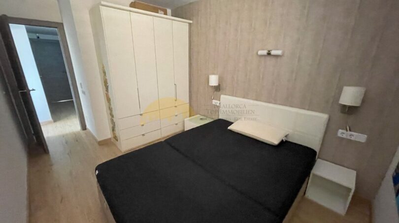 Schlafzimmer mit Doppelbett, weißem Kleiderschrank und Wandlampen im renovierten Strandapartment Magaluf