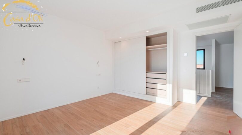 Helles Schlafzimmer mit Einbauschrank und Holzparkett im Neubau-Landhaus bei Porto Cristo