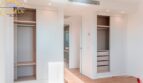 Helles Schlafzimmer mit zwei offenen Einbauschränken und Parkettboden im Neubau-Landhaus bei Porto Cristo