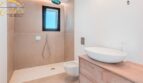 Modernes Badezimmer im Neubau-Landhaus Porto Cristo mit bodenebener Dusche, Hänge-WC und Aufsatzwaschbecken