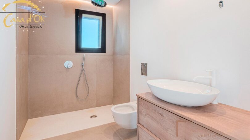 Modernes Badezimmer im Neubau-Landhaus Porto Cristo mit bodenebener Dusche, Hänge-WC und Aufsatzwaschbecken