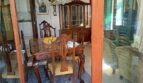 Elegantes Esszimmer mit antikem Holzmobiliar, Kronleuchter und Vitrinenschrank in Alcúdia-Anwesen.