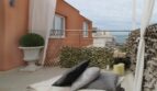 Penthouse-Terrasse mit Lounge-Bett, Kissen, Meerblick und elegantem Pflanzenschmuck in Strandnähe Palma