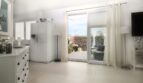 Helles Wohnzimmer mit weißem Kühlschrank und Terrassenzugang, Penthouse Palma de Mallorca