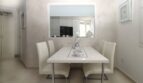Elegantes Esszimmer mit weißem Hochglanz-Tisch, Lederst ühlen und Wandspiegel im Penthouse Palma de Mallorca