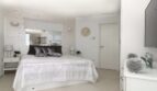 Elegantes Schlafzimmer im Penthouse Palma de Mallorca mit Doppelbett, Marmor-Akzentwand und hochwertiger Ausstattung.