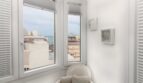 Heller Erker mit weißem Sessel, Meeresblick und Stadtpanorama im Penthouse nahe Strand, Palma de Mallorca.
