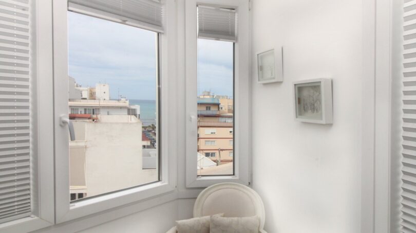 Heller Erker mit weißem Sessel, Meeresblick und Stadtpanorama im Penthouse nahe Strand, Palma de Mallorca.