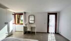 Luminoso dormitorio de la finca en Porto Cristo con escritorio, espejo, acceso al balcón y ventanas con vistas al mar.