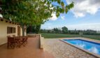Finca Porto Cristo: Terraza con muebles de madera, piscina y gran jardín bajo árbol frondoso
