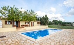 Finca Porto Cristo: outdoor area with blue pool, natural stone floor and covered terrace with seating area