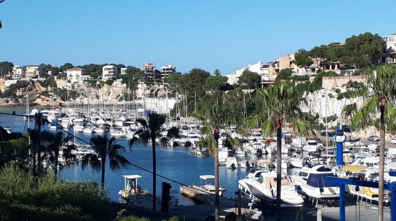 Puerto de Porto Cristo con veleros blancos, acantilados y casas mediterráneas – vista al mar de la finca