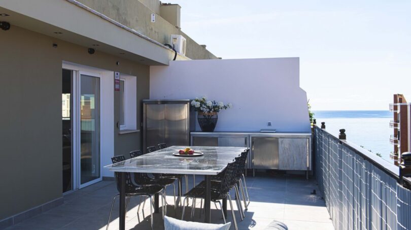 Dachterrasse des Luxus-Penthouses in Palma mit Esstisch, Outdoorküche und Meerblick