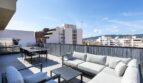 Sonnige Dachterrasse des Luxus-Penthouses in Palma mit Lounge, Esstisch und Stadtpanorama-Blick.