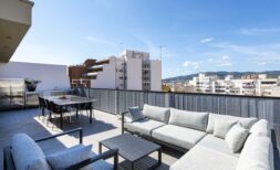 Sonnige Dachterrasse des Luxus-Penthouses in Palma mit Lounge, Esstisch und Stadtpanorama-Blick.