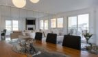 Offener Wohn- und Essbereich des Luxus-Penthouses in Palma mit elegantem Holztisch und heller Sofaecke